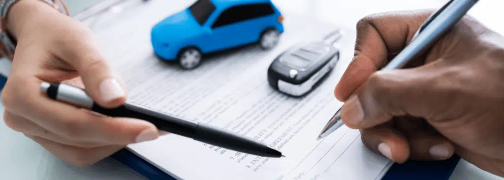 Two hands fill out a form for a car title loan without title in hand.